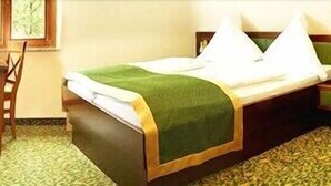 Une chambre d’hôtel avec un lit, un bureau, une chaise et une fenêtre.