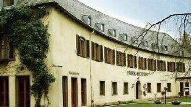 Un bâtiment doté d’un toit incurvé, de nombreuses fenêtres et d’une enseigne indiquant « Park Inn ».
