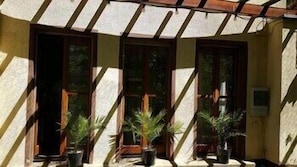 A building with a tiled roof, wooden doors, and potted plants. - Park-hotel Zirndorf (ZIRNDORF)