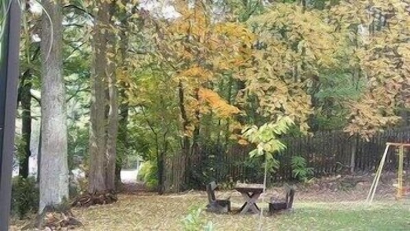 A garden with trees, a table, and a bench. - Park-hotel Zirndorf (ZIRNDORF)