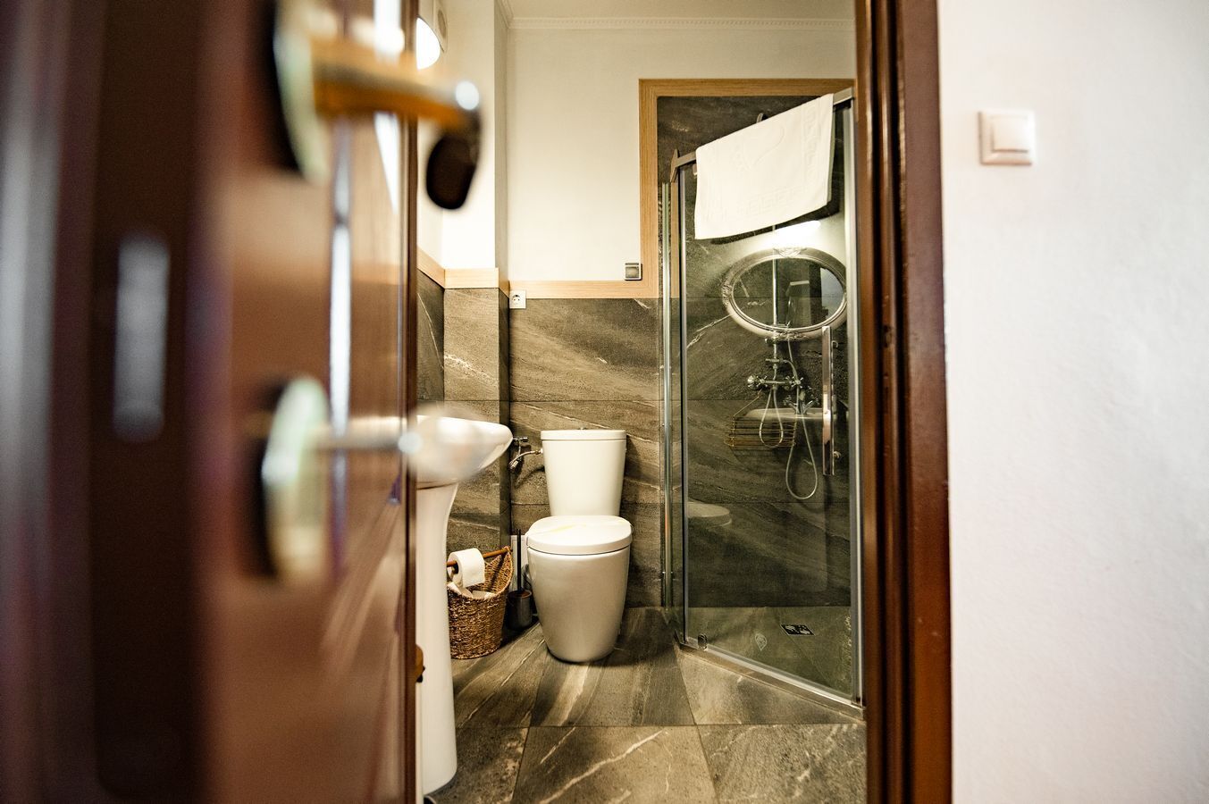 A bathroom with a toilet, a shower, and a glass-enclosed shower area.