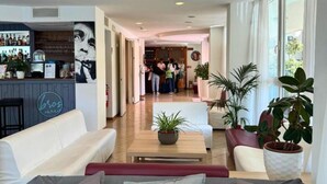 A spacious living area with a bar, sofas, and potted plants. - Apogeo (Rimini)