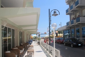 Un hôtel en bord de mer doté d’une terrasse, donnant sur la rue, et bénéficiant d’un ciel dégagé.