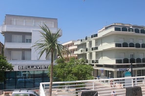 Un immeuble à plusieurs étages doté de balcons, d’un palmier et d’une enseigne indiquant « BELLAVISTA ».