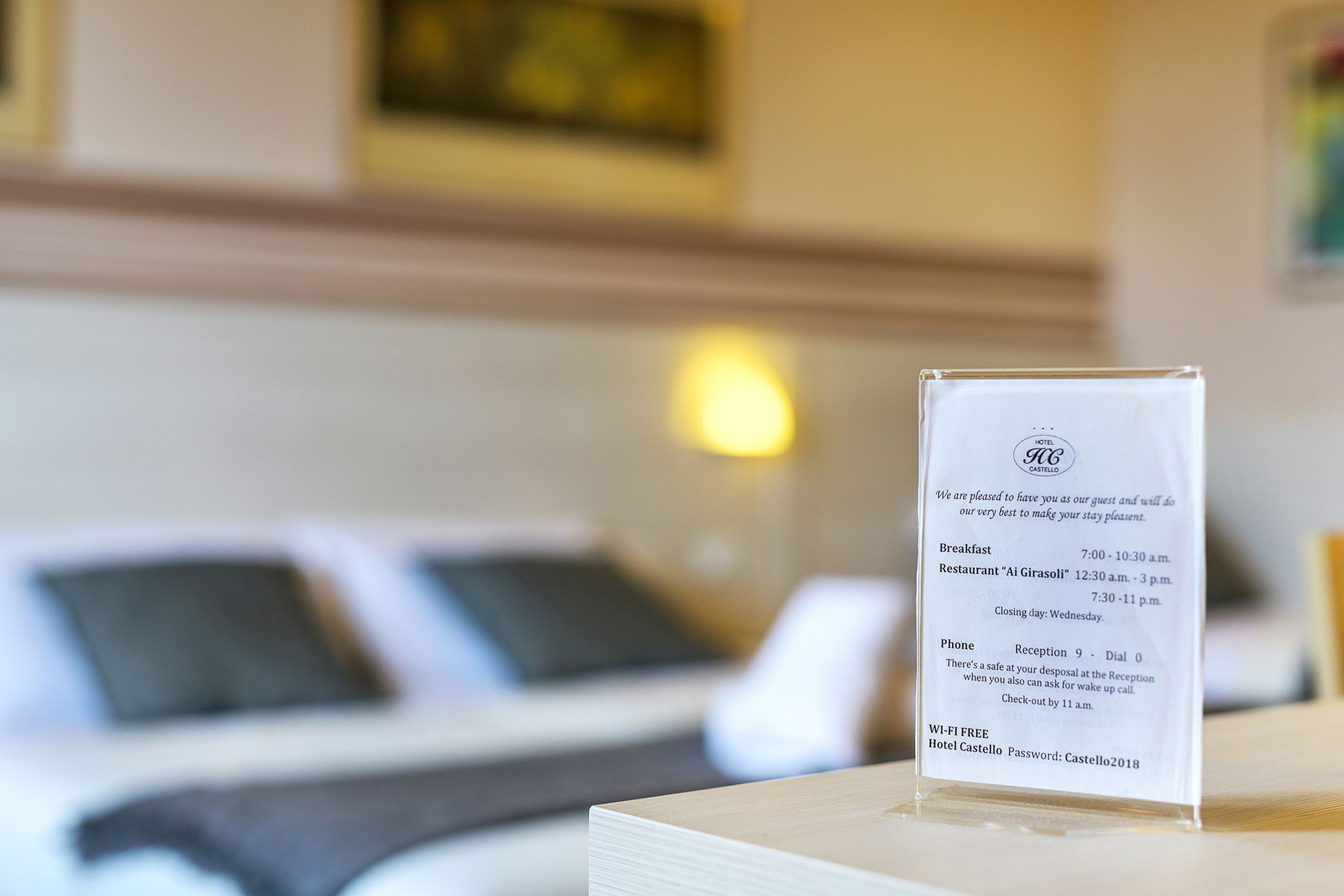 A hotel sign with breakfast and restaurant hours, reception phone number, and Wi-Fi availability.