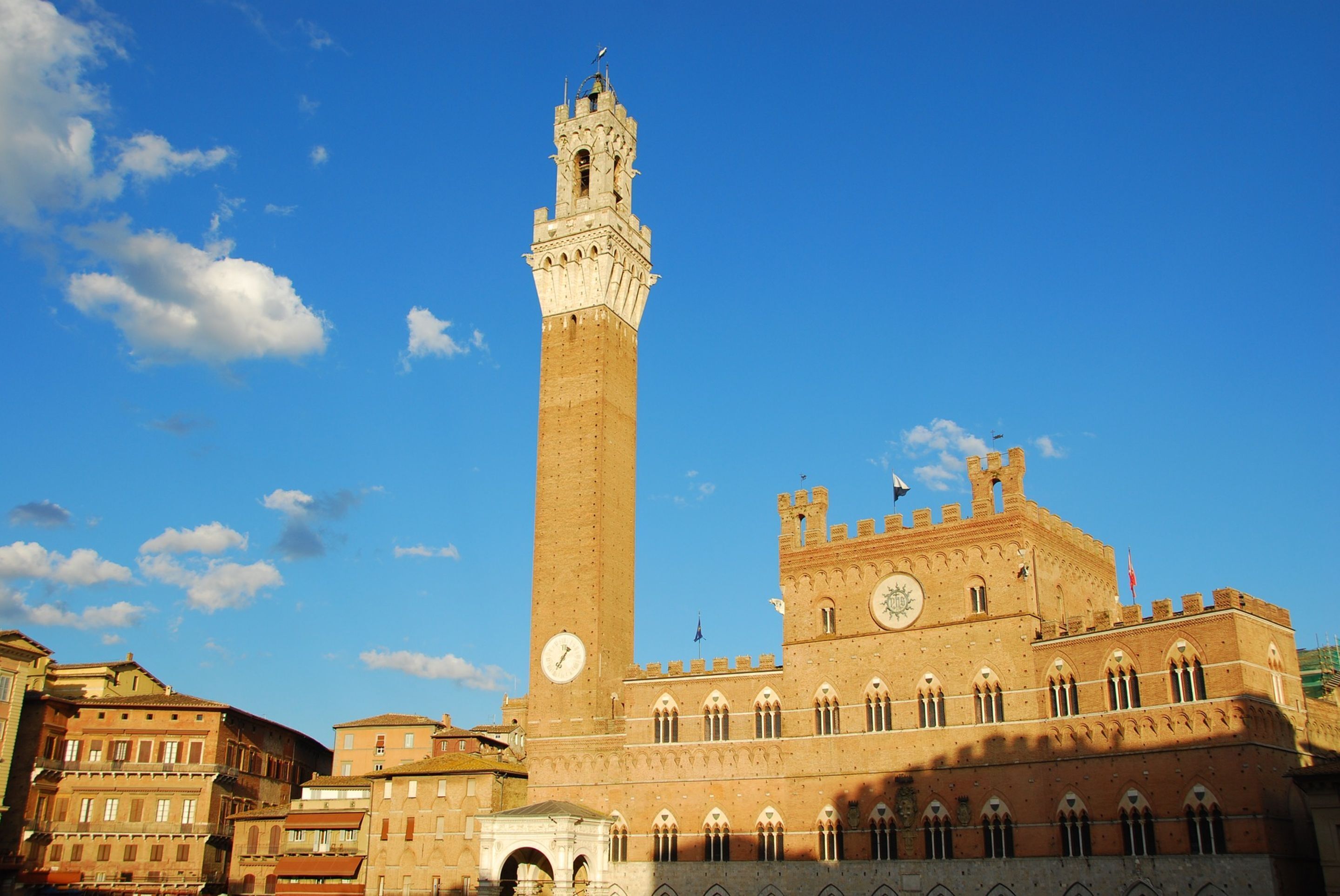 A historic building with a tall tower, arched windows, and a clock.