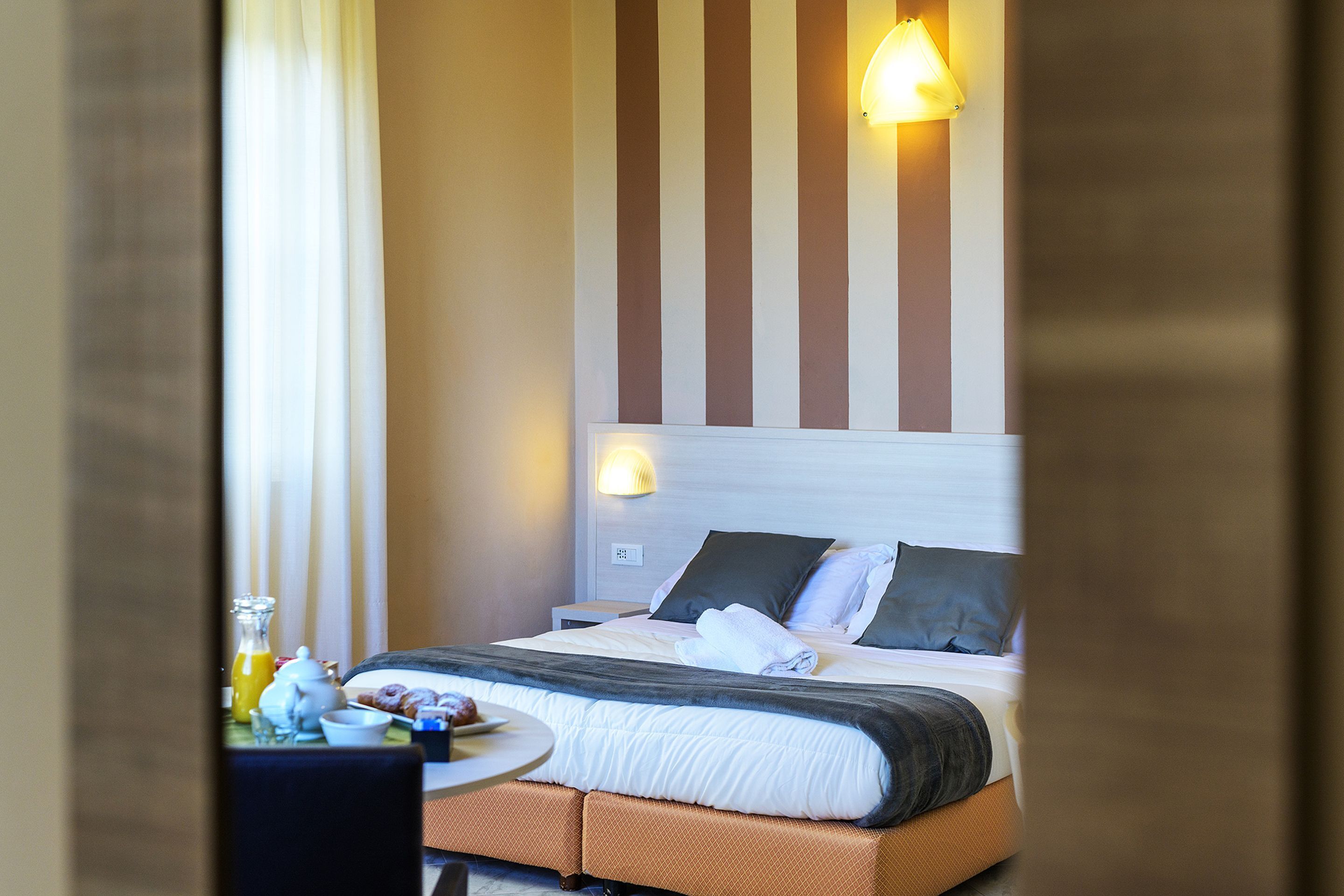 A hotel room with a bed, bedside table, and a breakfast tray.