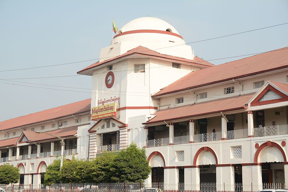 A large, white building with a red roof and a clock tower.