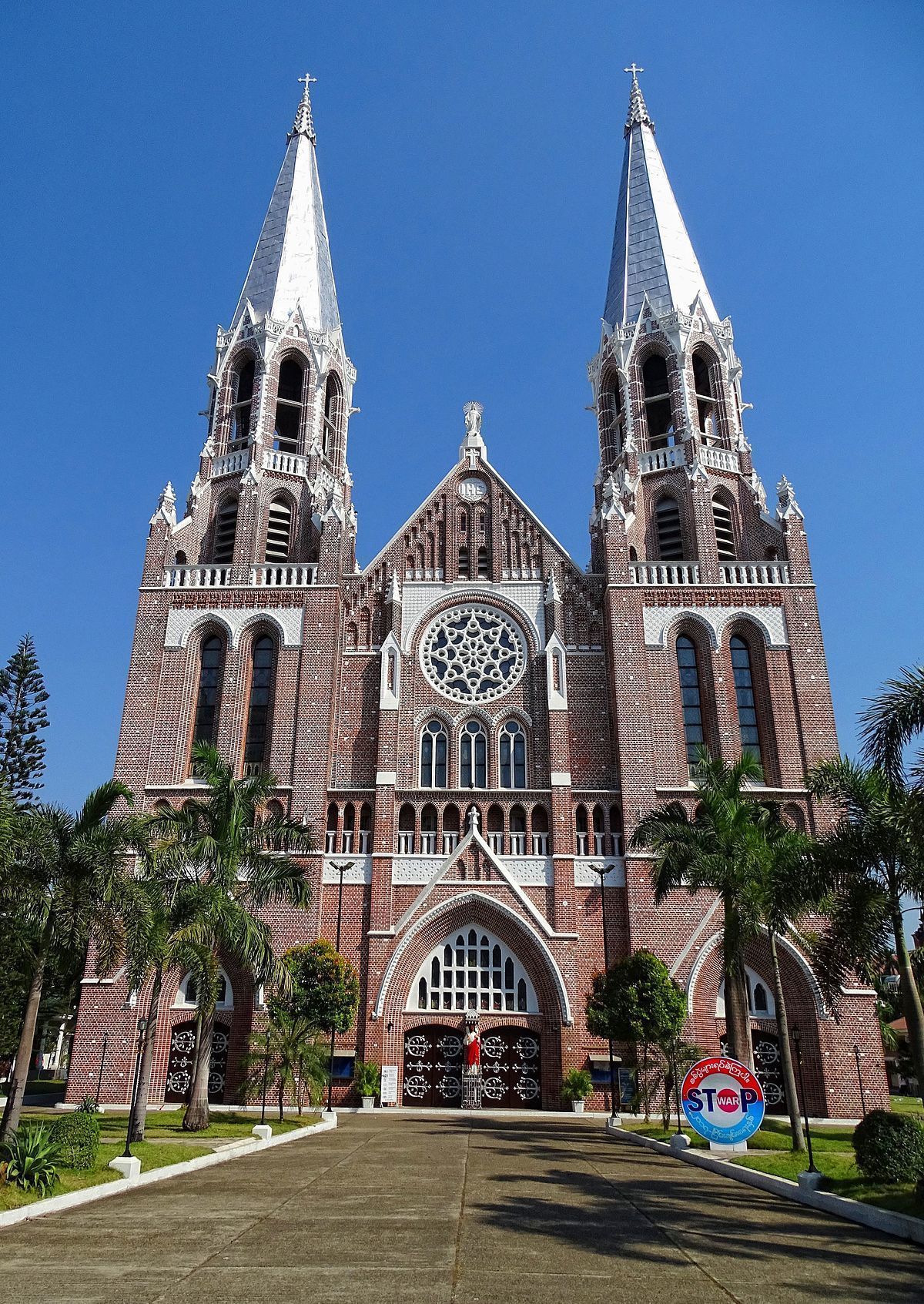 Une grande église historique, dotée de deux hautes flèches et d’une tour centrale abritant une horloge.
