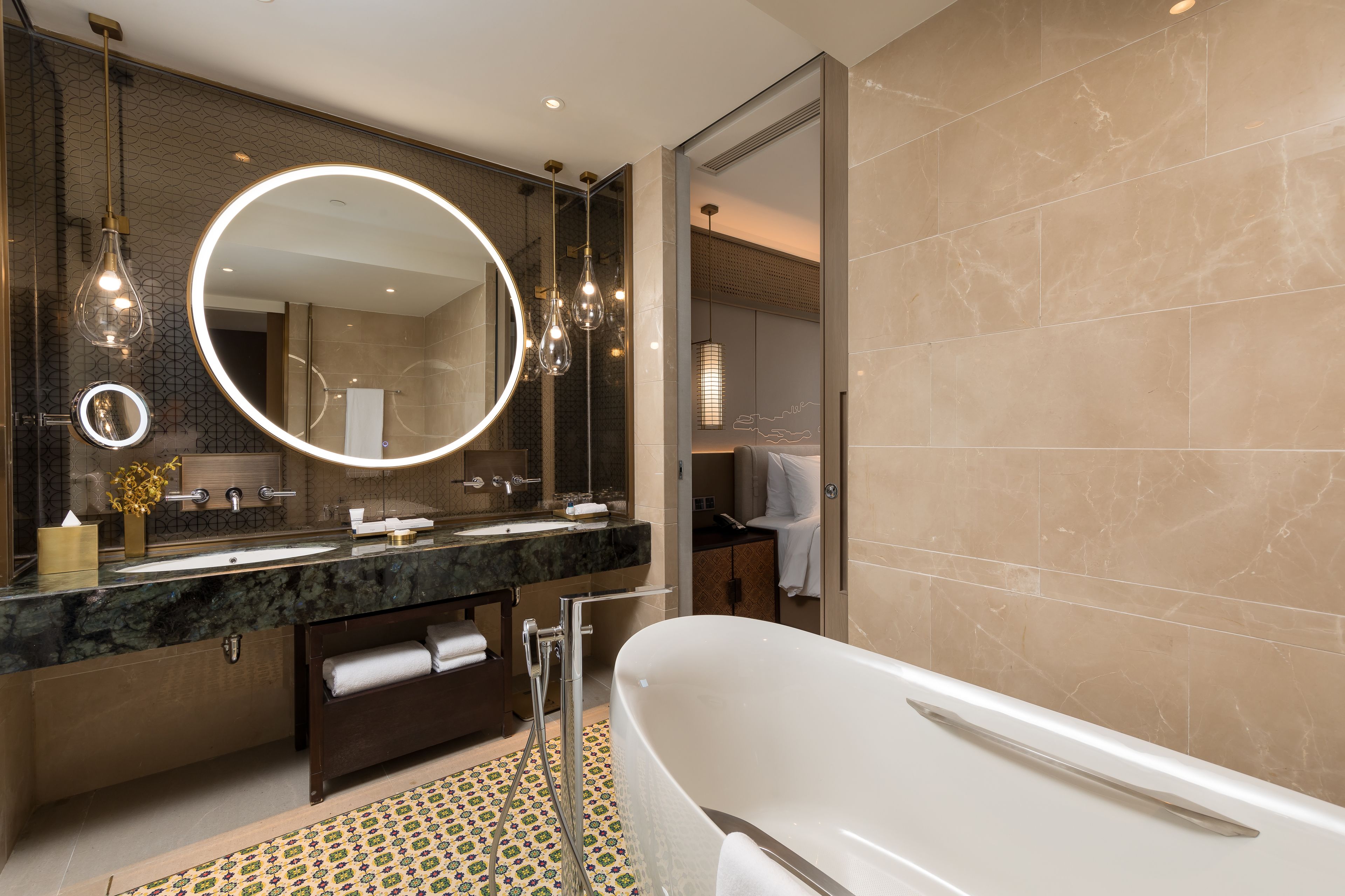 A modern bathroom with a large mirror, a bathtub, and a vanity with a sink and towel rack.