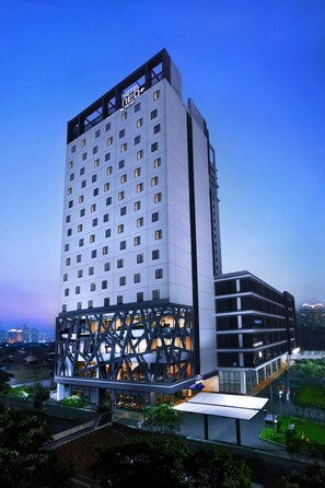 A modern hotel building with multiple floors, a prominent entrance, and a rooftop area. - Starray Hotel Kebayoran (Jakarta)