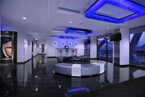 A modern hotel lobby with a central seating area, a reception desk, and a large window offering a view of the cityscape. - Starray Hotel Kebayoran (Jakarta)