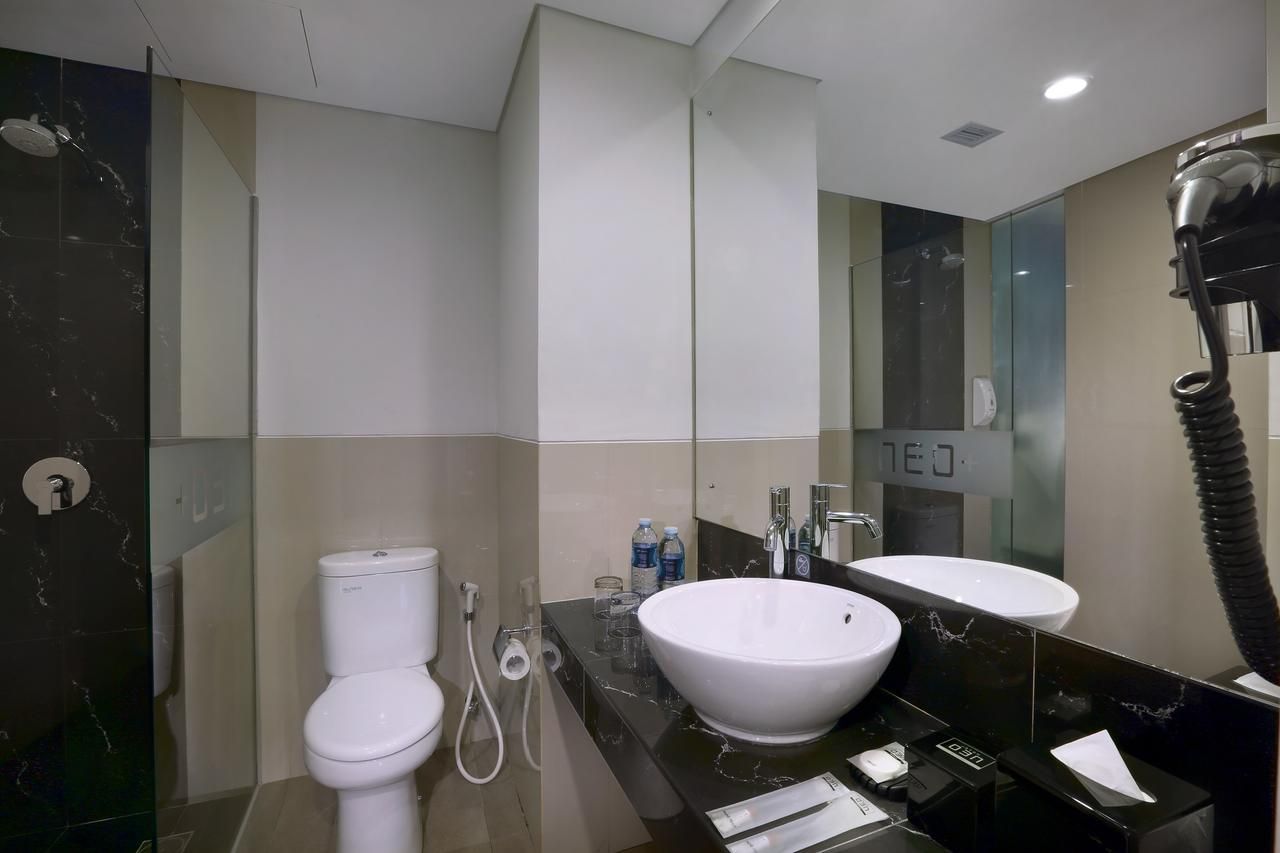 A modern bathroom with a toilet, bidet, and large sink.