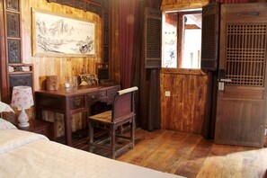 A traditional wooden room with a desk, chair, and a large framed artwork on the wall. - Huangshan Xishan Wutongqinyuan (Huangshan)