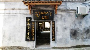 A traditional building with a tiled roof and a signboard with Chinese characters. - Huangshan Xishan Wutongqinyuan (Huangshan)