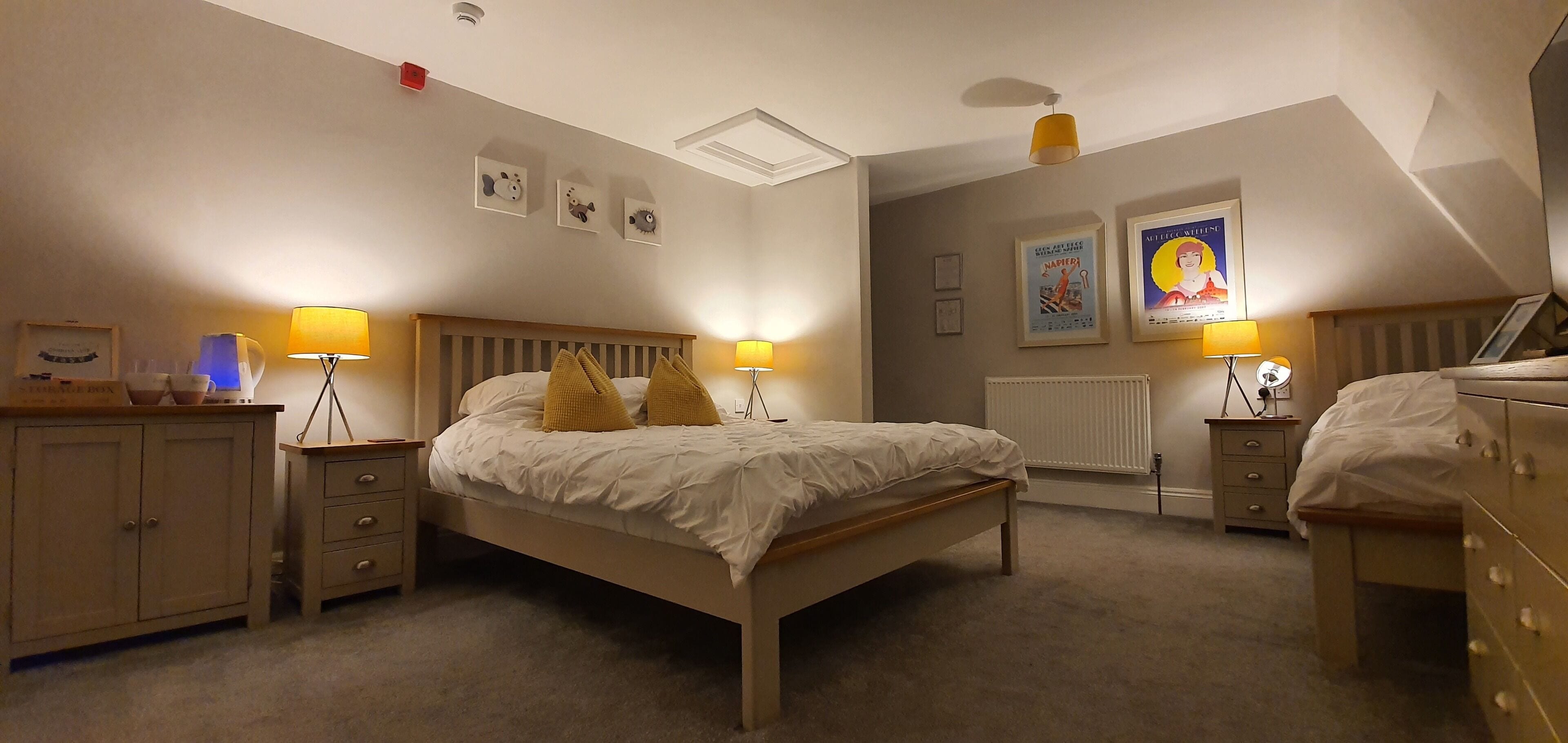 A bedroom with a bed, bedside tables, a wardrobe, and a radiator.
