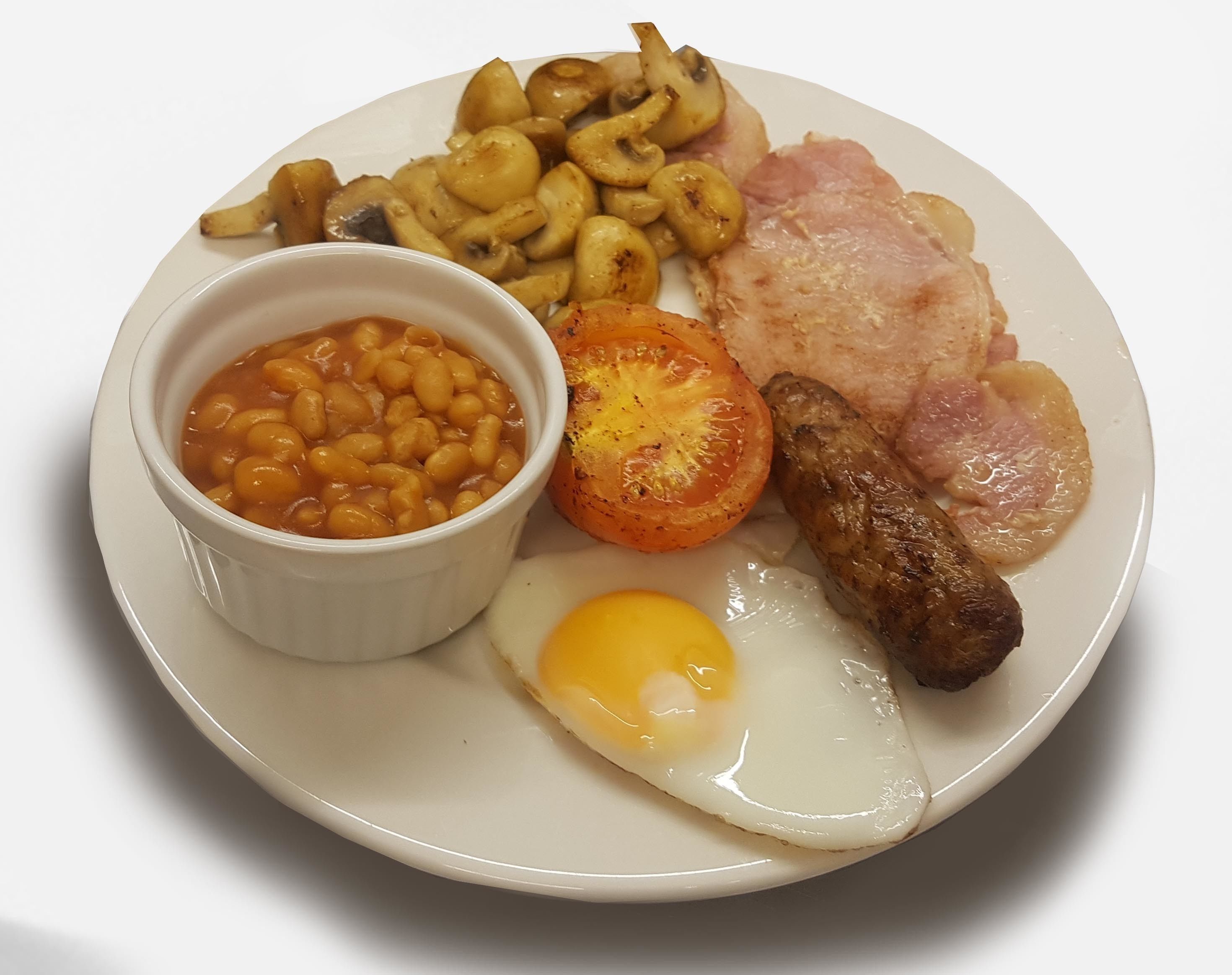 Un plato con un huevo frito, salchicha, tocino, puré de frijoles, papas asadas y tomate a la parrilla.