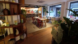 A modern interior with a dining area, wooden shelves, and large windows. - YATS Colony (Yogyakarta)