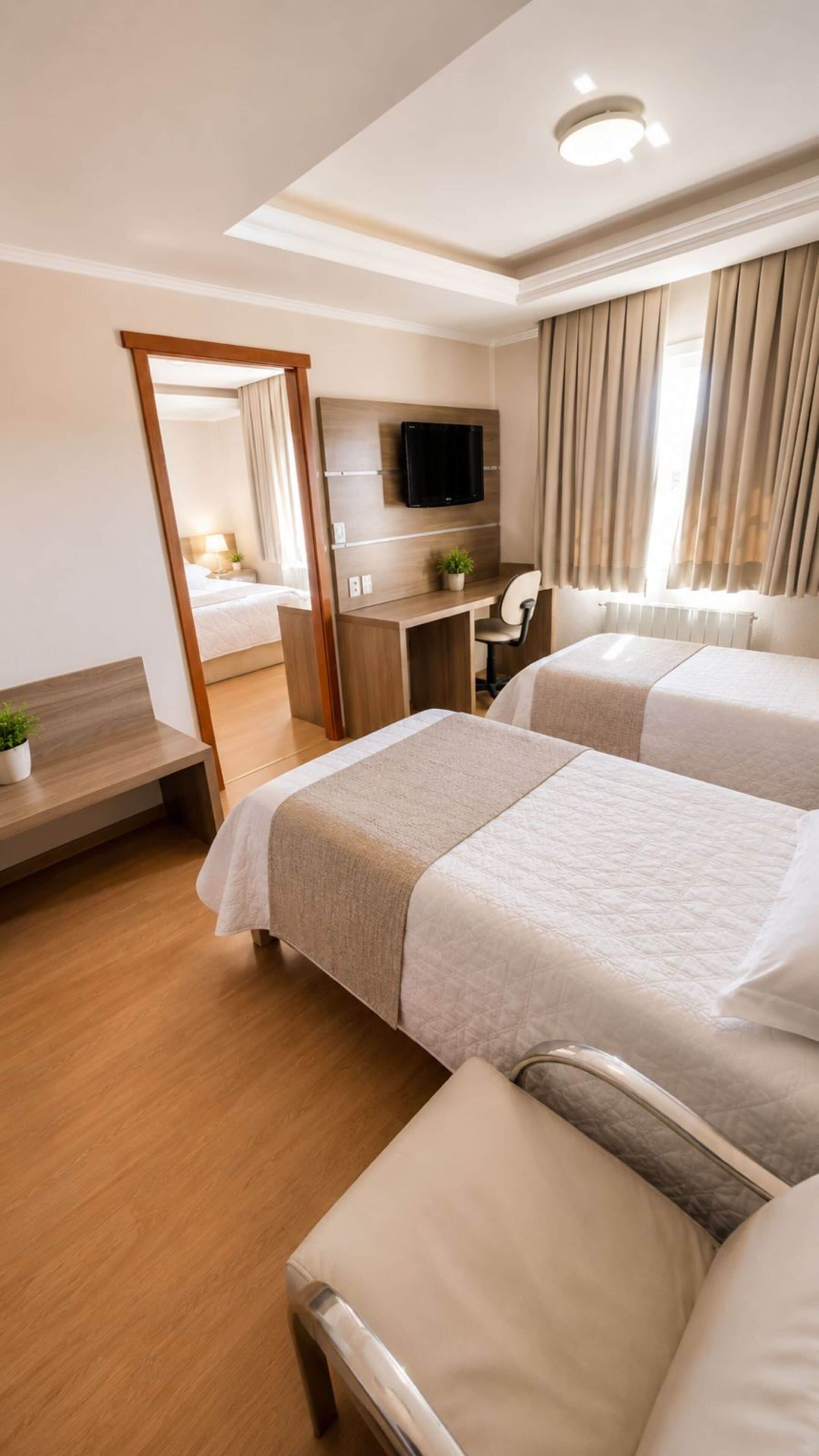Habitación de hotel con dos camas, un escritorio, un televisor y un espejo.