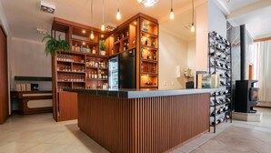 A bar area with wooden shelving, a refrigerator, and a wine rack. - Hotel Prata Villaggio (Nova Prata)