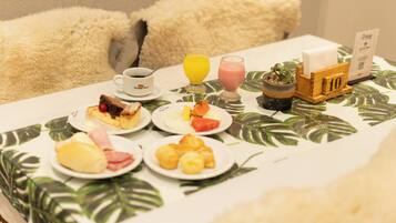 A breakfast table with plates of food, a coffee cup, juice glasses, a small plant, and a wooden sign with the number 10.