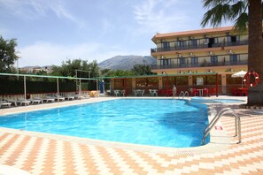 Una piscina al aire libre, sombrillas, tumbonas