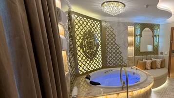 A luxurious bathroom with a marble staircase, a bathtub, and a decorative wall panel.