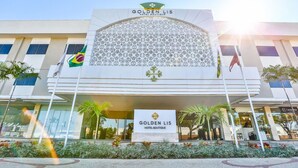 Außenansicht des Golden Lis Hotel Boutique mit moderner Fassade, großem gemusterten Glasfenster und der brasilianischen Flagge.