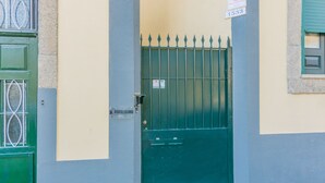 A green metal gate with a sign reading "Doo To Island" and a number "1533" on a building facade. - Porto Island (Porto)