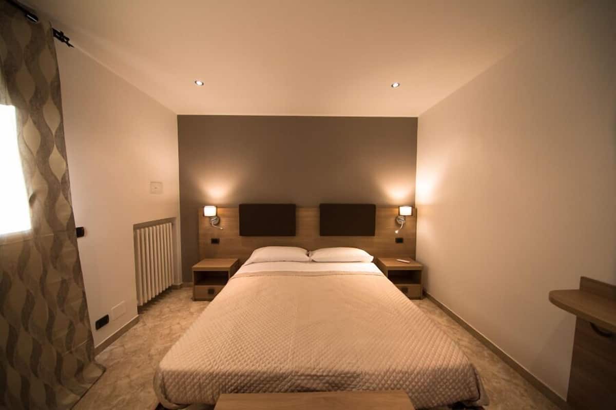 Deluxe kamer | Luxe beddengoed, een minibar, een kluis op de kamer, een bureau