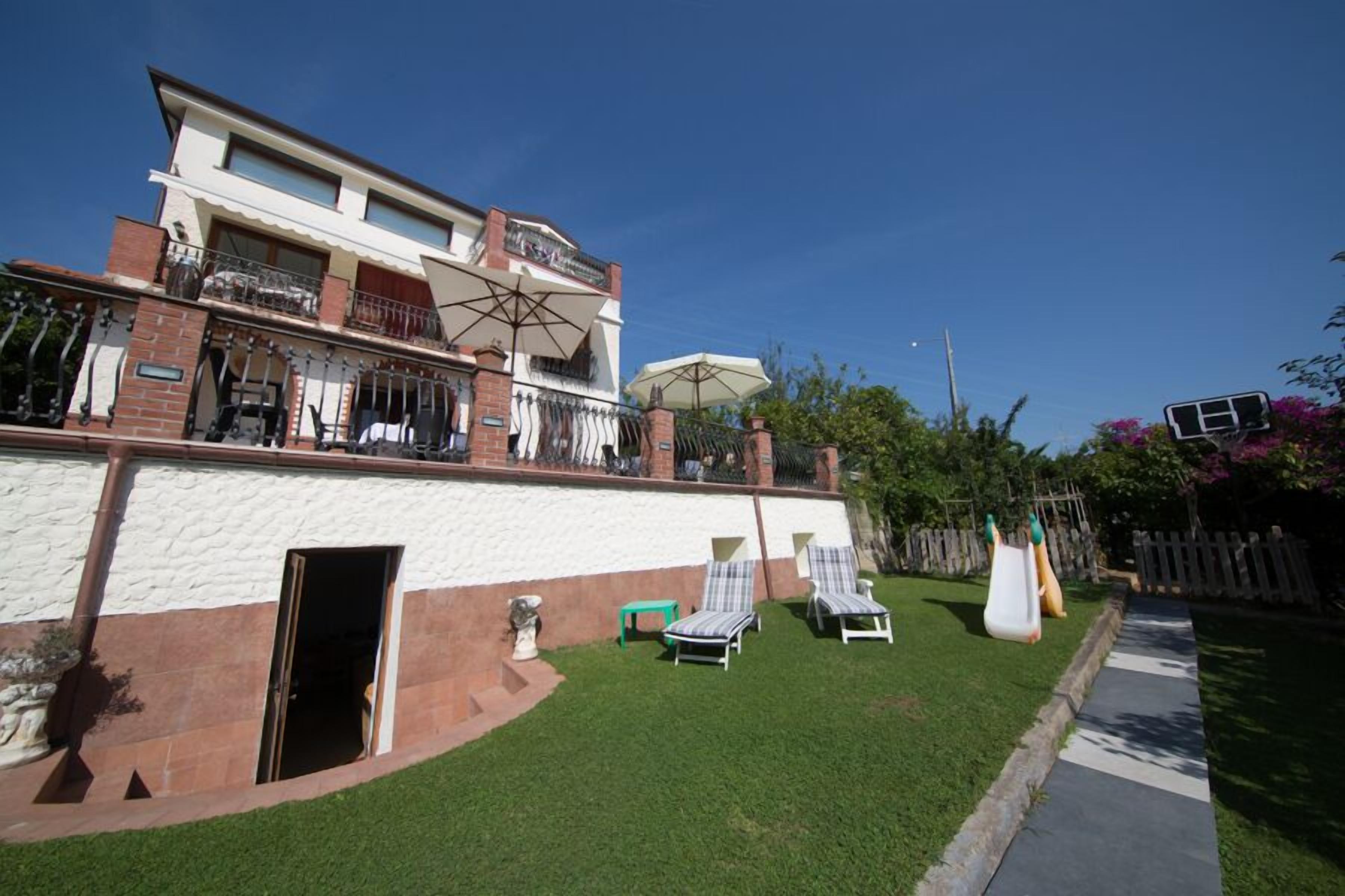 Un bâtiment à deux étages doté d’un balcon, d’un espace extérieur aménagé pour s’asseoir et offrant une vue sur un ciel dégagé.