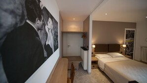 A bedroom with a bed, bedside table, and a large painting on the wall. - La Dolce Vita (Taggia)