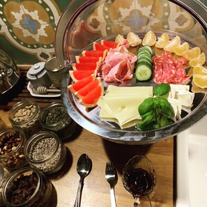 A glass platter with various cheeses, cured meats, and vegetables. - Villamilsten Bed & Breakfast (Lidköping)