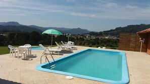 Alberca al aire libre y camastros 