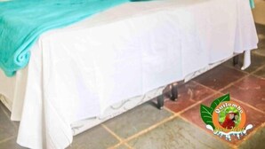 Une chambre à coucher comprenant un lit, une table de chevet, un escalier en bois et un petit réfrigérateur.