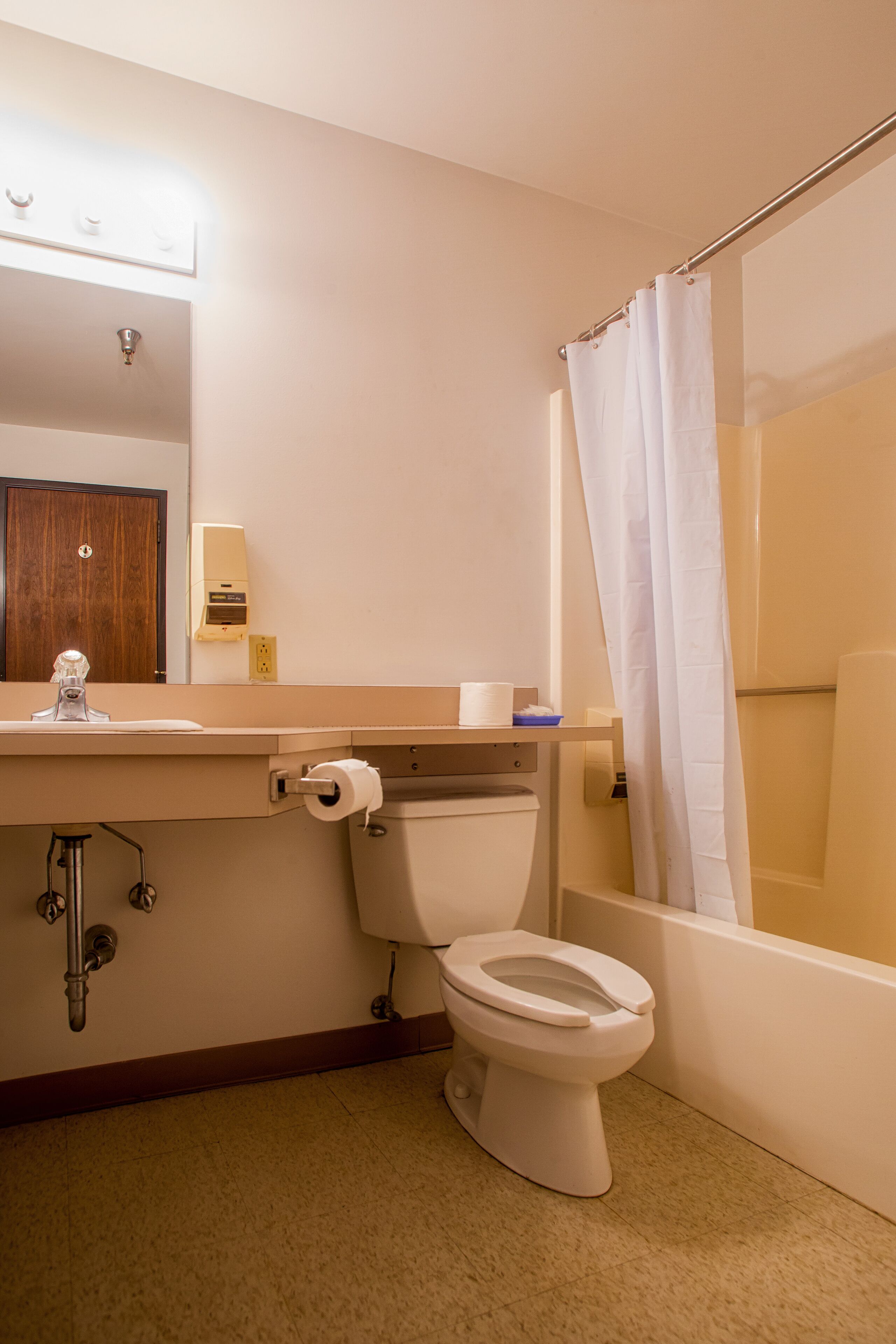 A bathroom with a toilet, sink, and shower curtain.