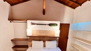 A bedroom with a bunk bed, a wooden ceiling, and a bedside table with a lamp. - Pousada Raízes do Brasil (Porto Seguro)