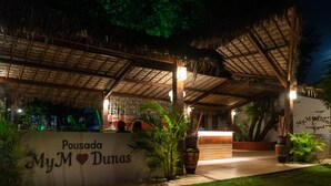A covered outdoor area with a sign reading "Pousada My M Dumas."