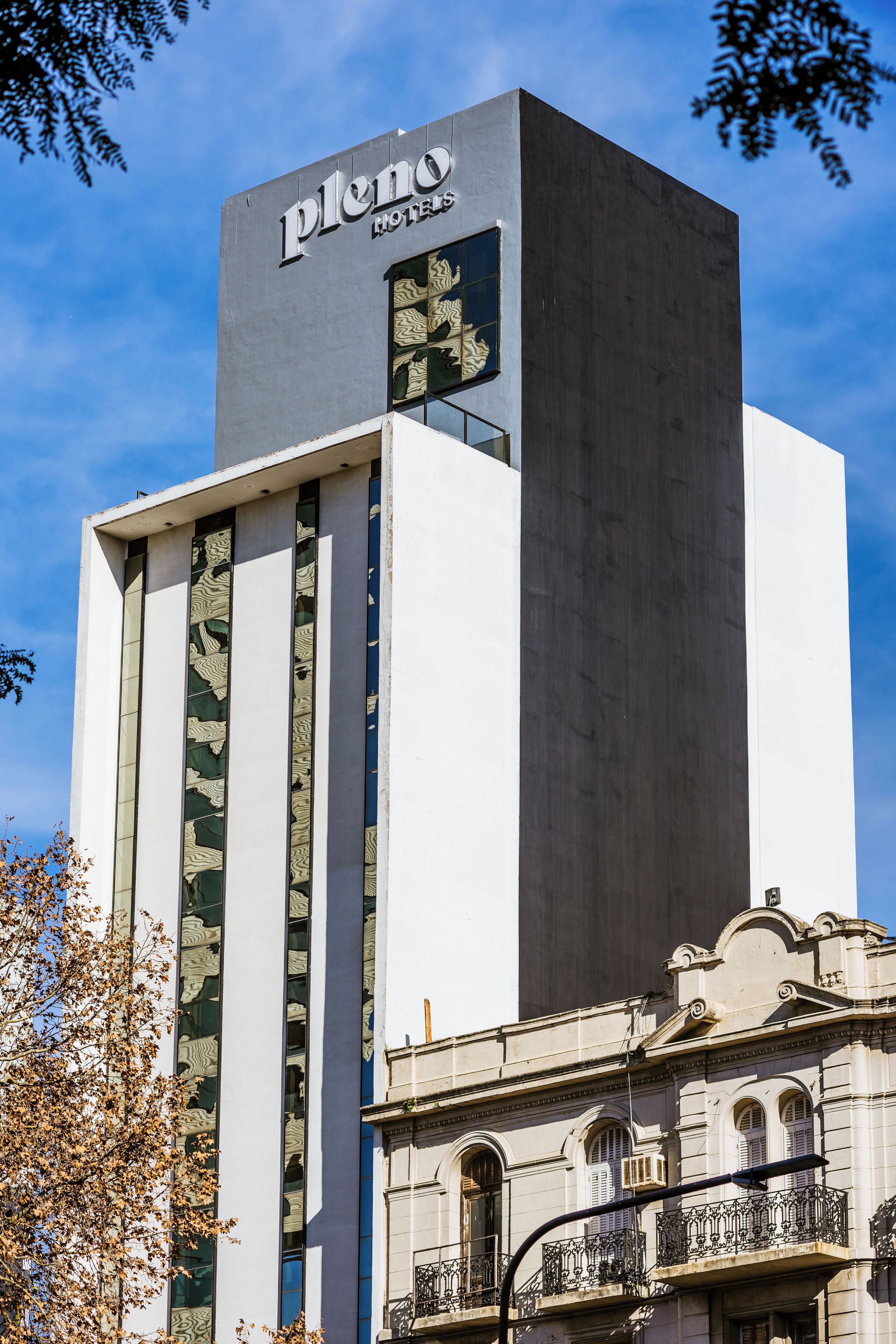 Um edifício moderno de hotel com uma placa destacada que diz "pleno hotels".