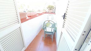 A narrow corridor with a chair and potted plants. - Hotel Casa Nicola (Serrara Fontana)