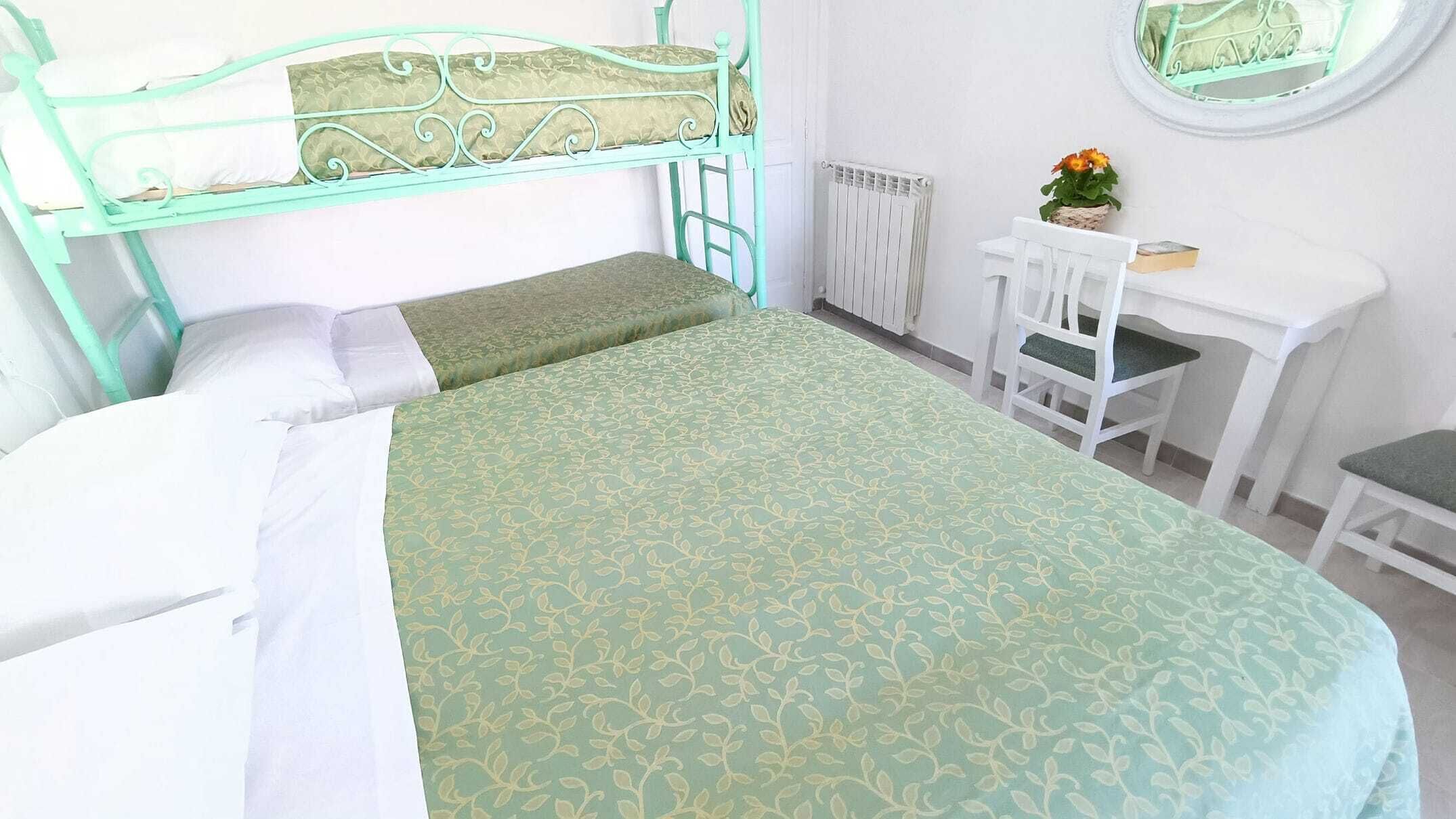 A bedroom with a bed, a desk, and a chair.
