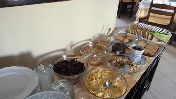 A buffet table with various food items and utensils.