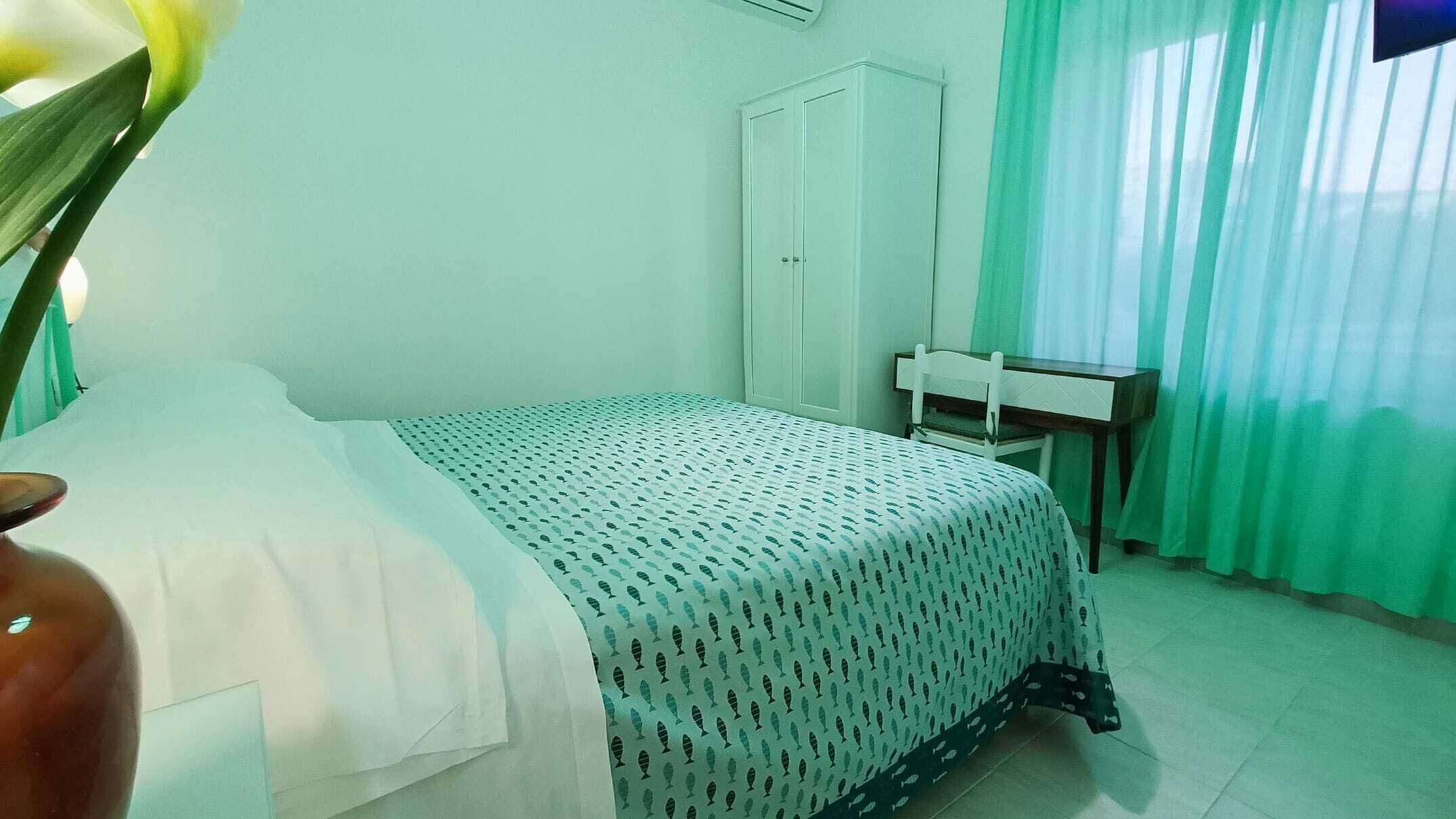 A room with a bed, a desk, and a wardrobe.