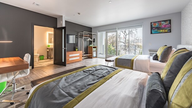 Een moderne hotelkamer met een groot bed, een bureau en uitzicht op het groen.