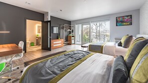 Une chambre d’hôtel moderne dotée d’un grand lit, d’un bureau et offrant une vue sur l’extérieur.