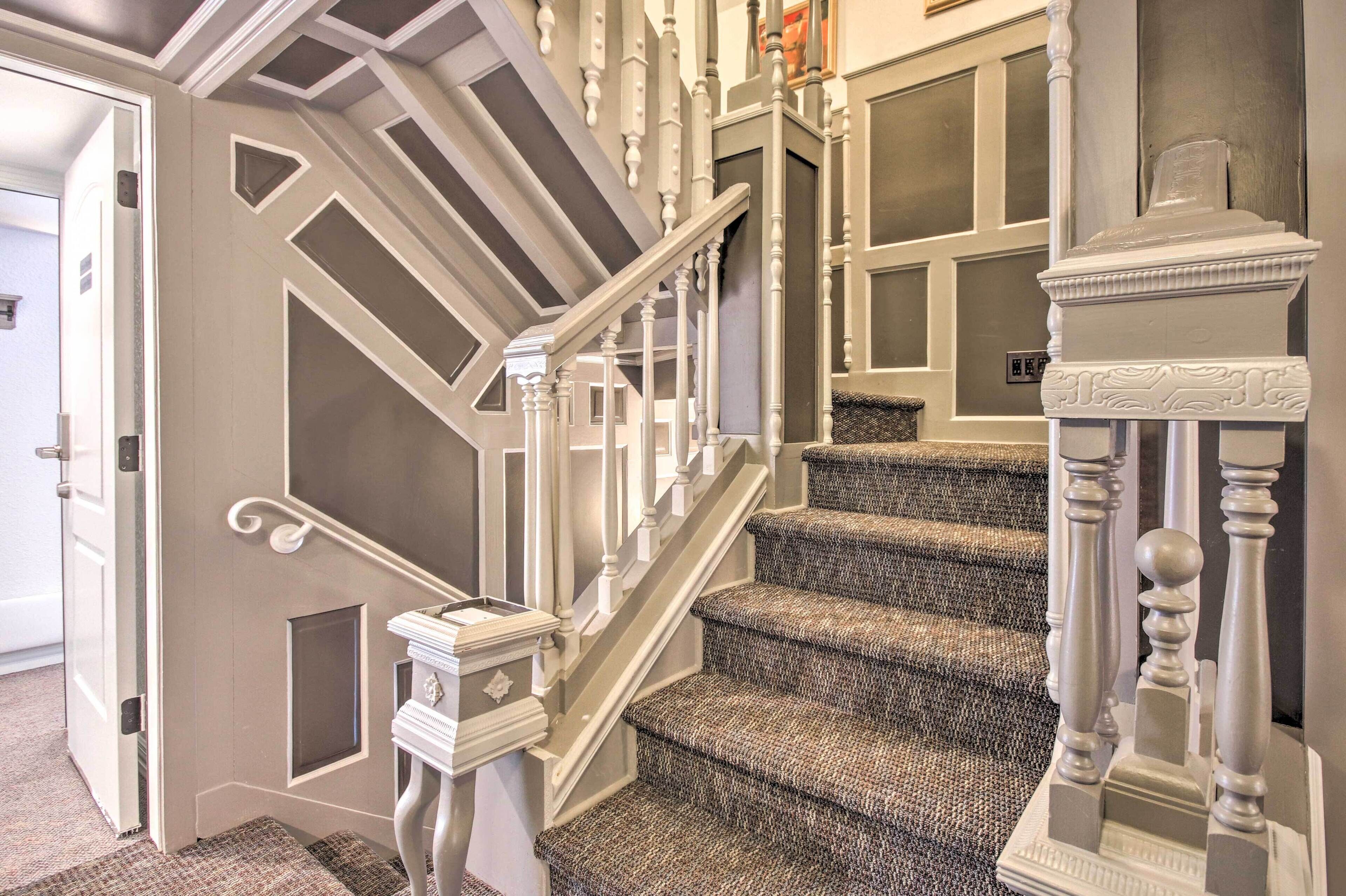 A staircase with a white balustrade and a carpeted landing.