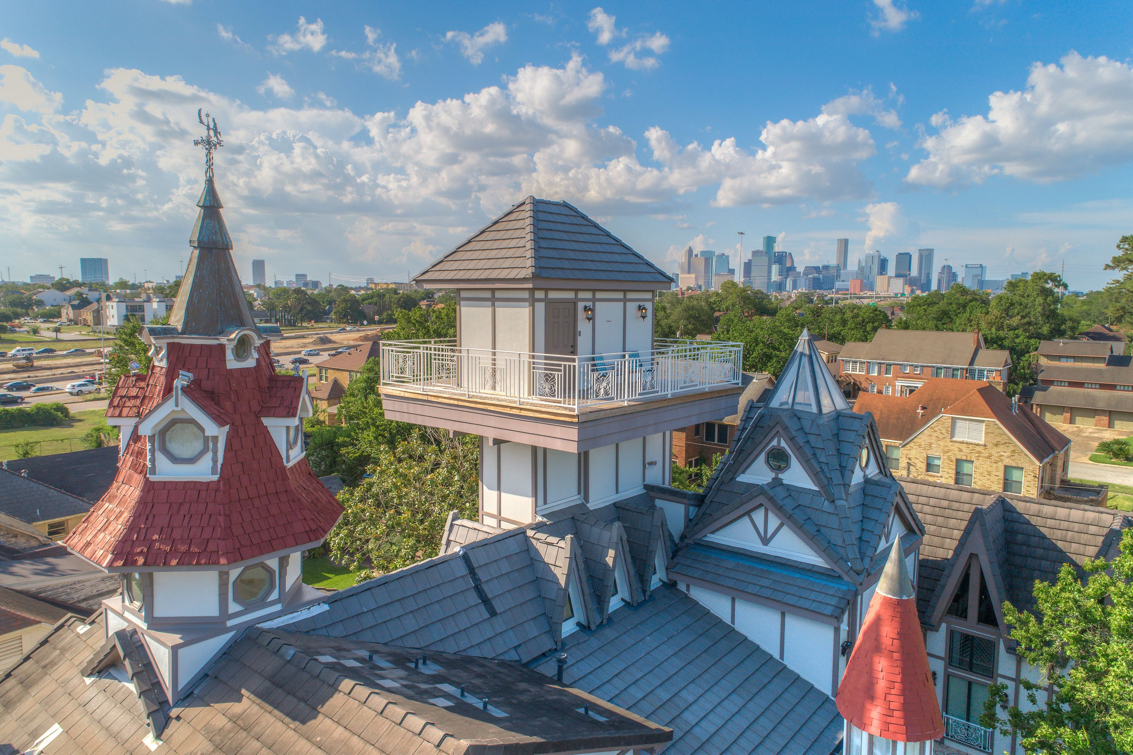 A residential area with a prominent tower-like structure with a balcony, surrounded by houses with varied roof designs.
