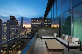 Enjoy a panoramic city view from the spacious balcony with a comfortable seating area. at The Laura Hotel, Houston Downtown, Autograph Collection