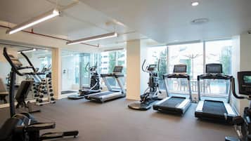 A gym with treadmills, elliptical machines, and weightlifting equipment.