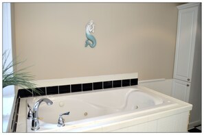A bathroom with a white bathtub, a white sink, and a white cabinet. - Opis Realty-Spacious Metro Atlanta Home (Conyers)